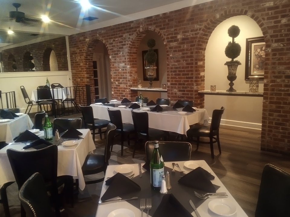 Warm dining room with tables and framed wall decor.
